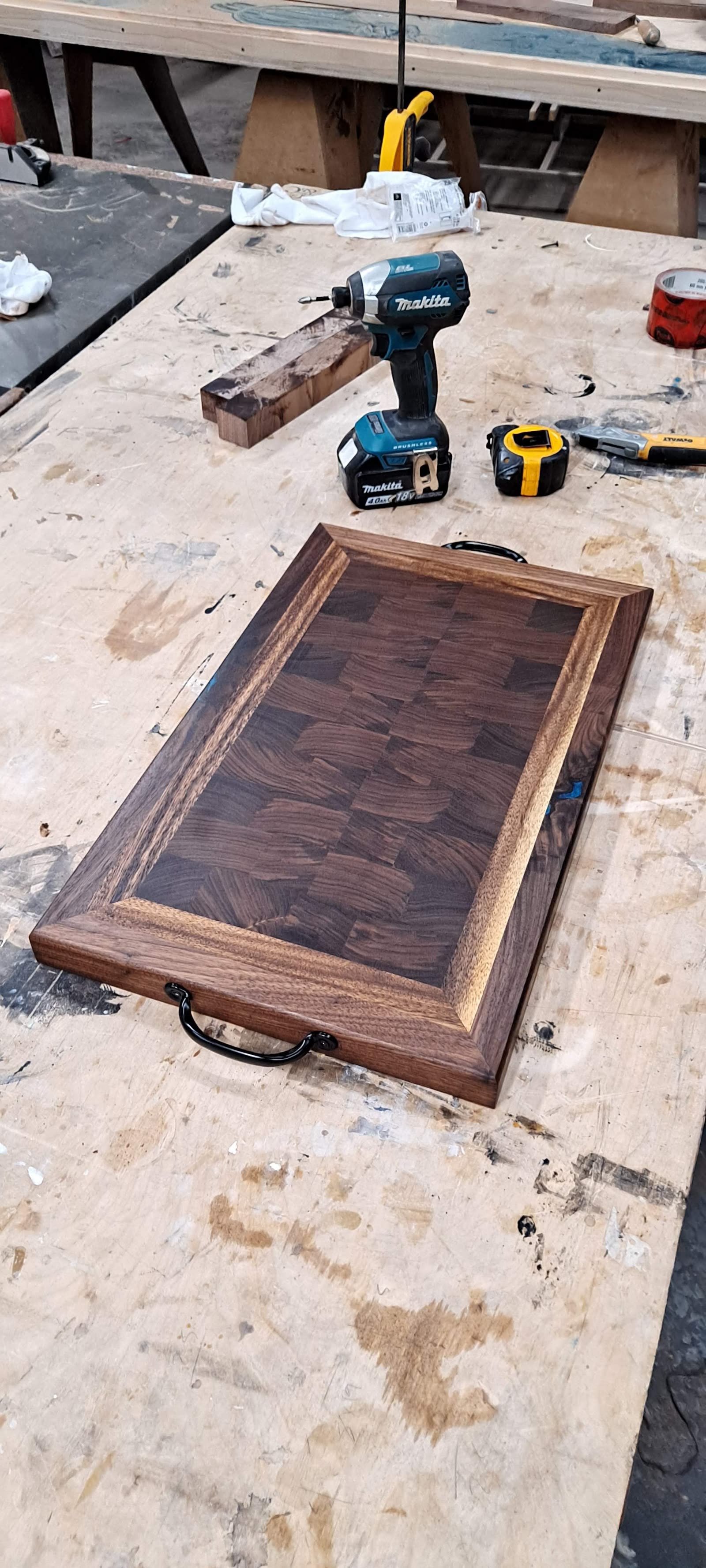 Framed end-grain serving board with cut-in side handles, finished and lying on the workbench